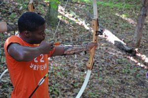Camper aims arrow at archery
