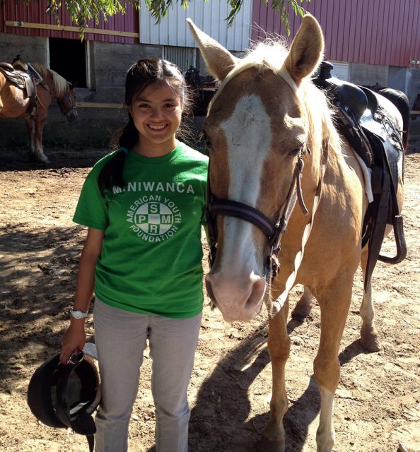 Camp Miniwanca Junior smiles next to her horse-crop